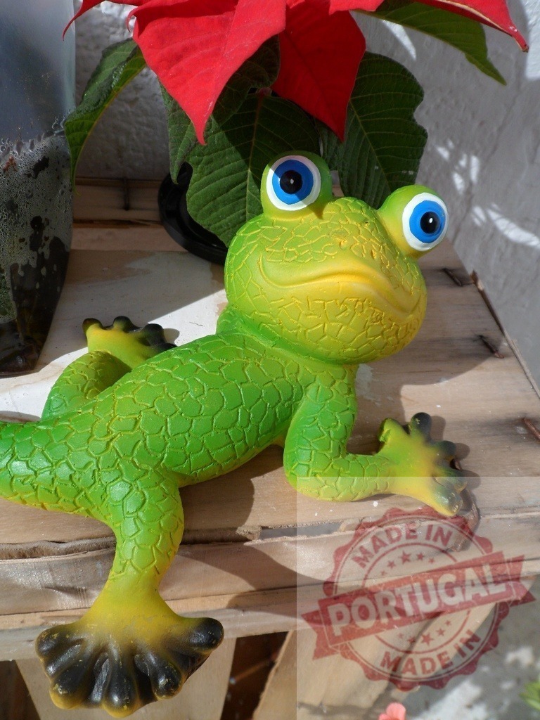 Green frog figurine standing on wooden shelf | Green frog figurine with big eyes sitting on a a weathered wooden shelf - Realisiert mit Pictrs.com