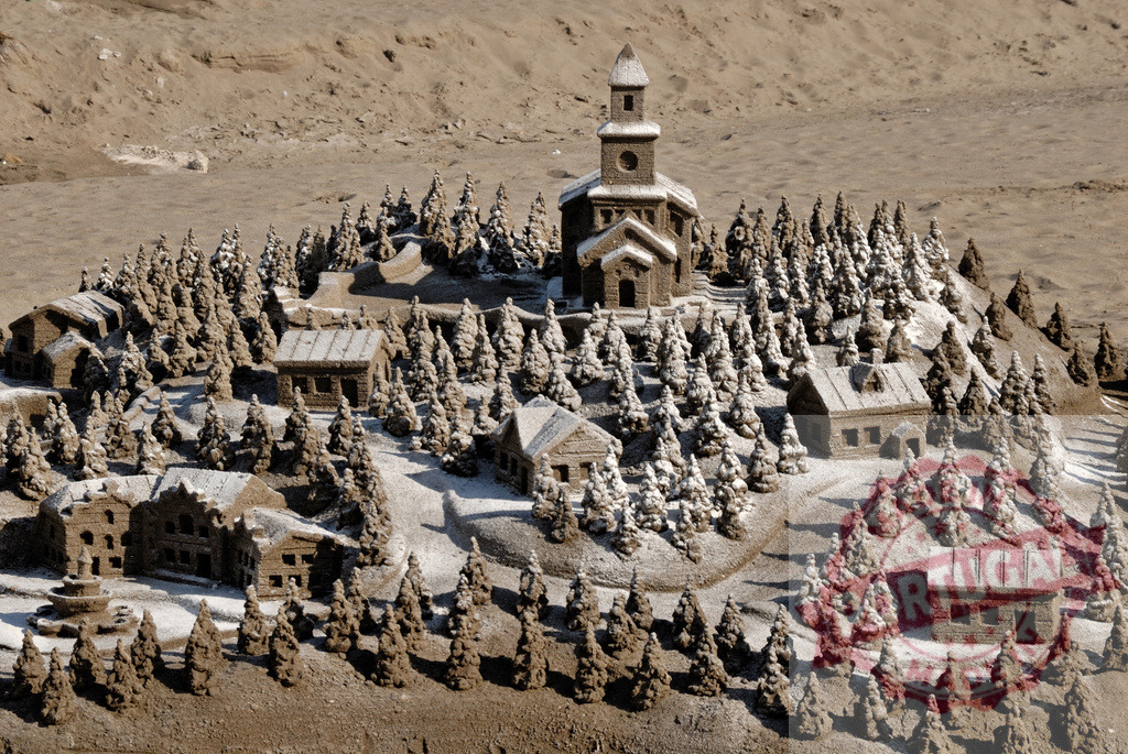 Sandcastle village with church, houses and fir trees creating a winter wonderland on the beach | Intricate sandcastle village depicting a winter scene, complete with snow-covered houses, church, and fir trees, showcasing creativity and artistry on a sandy beach - Realized with Pictrs.com