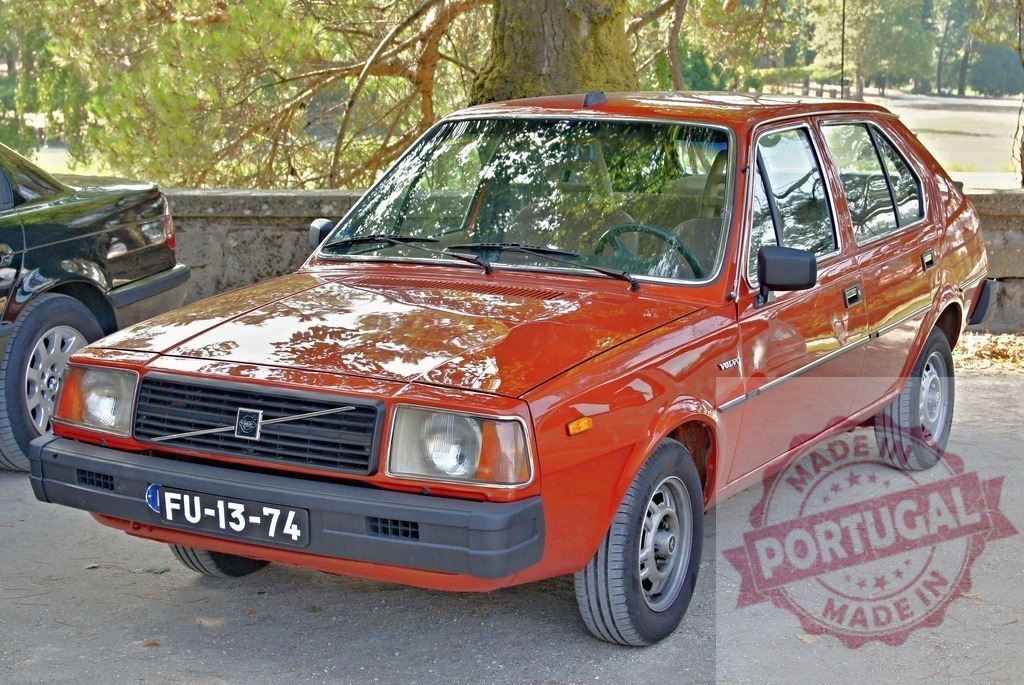 Shiny red Volvo 343 parked near a tree in Portugal | Classic red Volvo 343 glistening in the sun, parked near a tree, showcasing its vintage charm and Portuguese license plate - Realisiert mit Pictrs.com