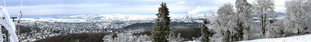 Panorama Aufnahme vom Poppenberg zeigt die Stadt Brilon im Winter mit Schnee und Eis bedeckt. | Eiskristalle am Skilift von Brilon auf dem Poppenberg. Im Hintergrund dieses Panorama Bildes zeigt sich unten liegend die Stadt mit der Propsteikirche und den Häusern bis zum Industriegebiet.