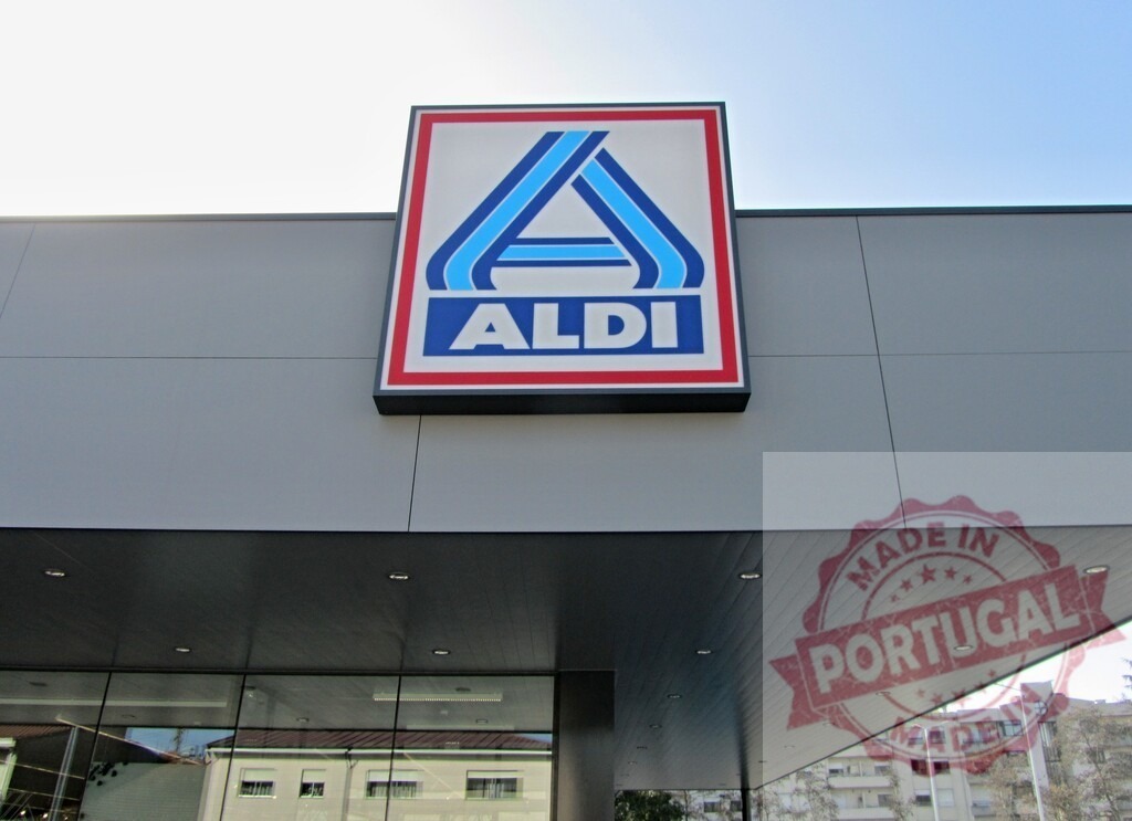 ALDI logo sign on modern supermarket building exterior | ALDI logo displayed on the modern facade of a supermarket against a clear sky - Realisiert mit Pictrs.com