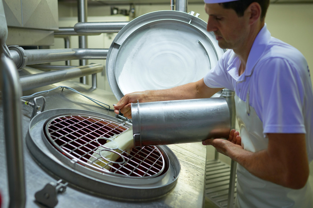 Sennerei Hittisau | Hittisau, Austria - July 29, 2019: Sennerei Hittisau; Betriebsleiter Mathias Greber beim beimengen der Kulturen in die Milch. - Realisiert mit Pictrs.com