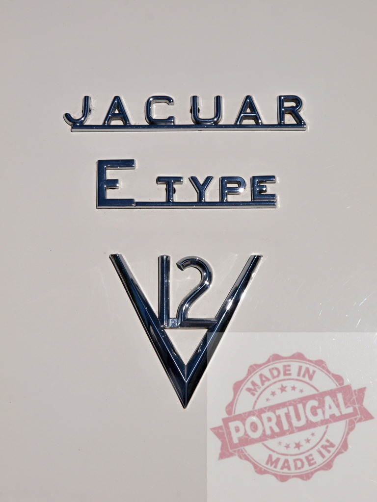 Chrome Jaguar E-Type V12 logo shining on a classic white car body | Jaguar E-Type V12 Logo Exhibiting Classic British Automotive Design - Realized with Pictrs.com