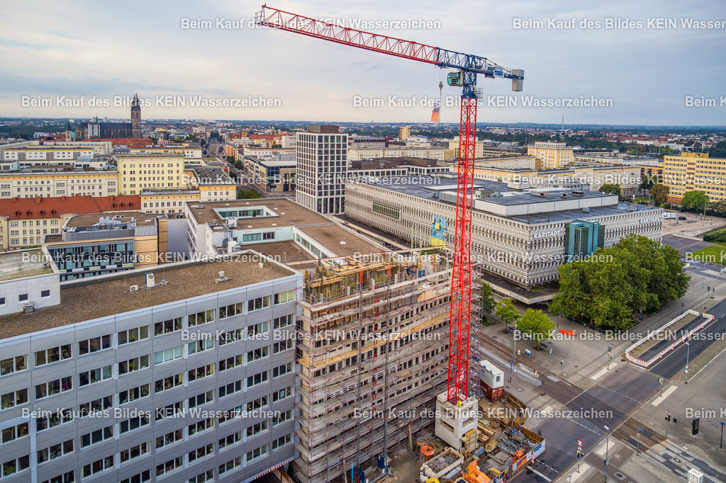 MWG-Baustelle_September_2023-0013 | Die Luftaufnahme aus der Drohne zeigt den fortgeschrittenen Rohbau der neuen Firmenzentrale, der inzwischen die Höhe der umliegenden Gebäude erreicht hat. Die nahe Perspektive ermöglicht einen detaillierten Blick auf die Baustelle, die Bauarbeiten und die bereits errichteten Gebäudestrukturen. Die angrenzenden Straßen und Plätze sind menschenleer, da die Aufnahme am frühen Sonntagmorgen entstand und die Baustelle an diesem Tag ruhte. Die Aufnahme ist Teil einer über zwei Jahre entstandenen Baustellendokumentation und zeigt eine weitere wichtige Phase des Baufortschritts. Die Aufnahme ist Teil des Mitteldeutschen Bildarchivs von Luftbildfotograf Steffen Lehmann. - Realisiert mit Pictrs.com