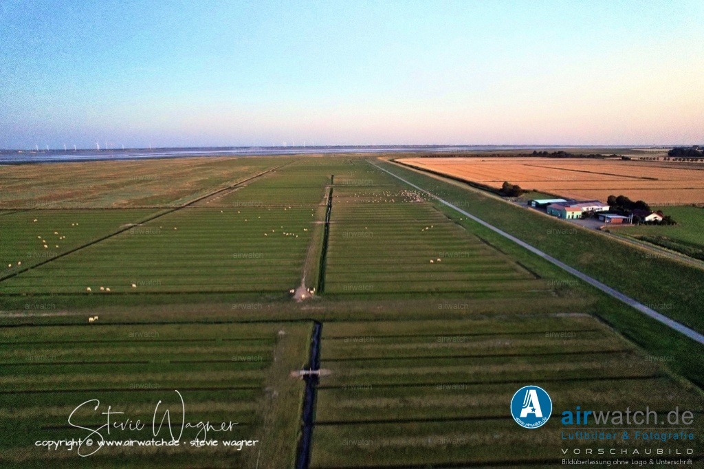 Nordsee, Nordfriesland, Nordstrand, Pohnshalligkoog - airwatch.de | Der Pohnshalligkoog ist der jüngste bewohnte Koog der Halbinsel Nordstrand in Schleswig-Holstein. Er ist als Ortsteil der Gemeinde Nordstrand angehörig. Die Pohnshallig, eine ehemalige Hallig, wurde durch die Burchardiflut im Jahre 1634 von der Insel Alt-Nordstrand abgerissen. Im 18. und 19. Jahrhundert wurden sukzessive ehemalig besiedelte Landstriche neu bedeicht und die Insel Stück für Stück neu in Richtung Osten ausdehnte. Im Jahr 1924 erfolgte die Eindeichung der Pohnshallig, nachdem die unbewohnte Hallig zeitweise durch die Schobüller zur Heugewinnung genutzt worden war.Größe und LageDer Pohnshalligkoog umfasst eine Fläche von etwa 695 Hektar und ist der östlichste und zweitgrößte Koog der Halbinsel Nordstrand. Die Eindeichung des Pohnshalligkoogs war 1924 abgeschlossen. Trotz der Schwierigkeiten bei der Errichtung des Deiches und des verschlammten Bodens konnten die ersten Pächter 1924 den Koog übernehmen. Fünf Jahre nach der Eindeichung wurden die Pachtverträge jedoch aufgelöst und das gesamte Land der “Gemeinnützigen Siedlungsgesellschaft Deutscher Osten” übergeben.