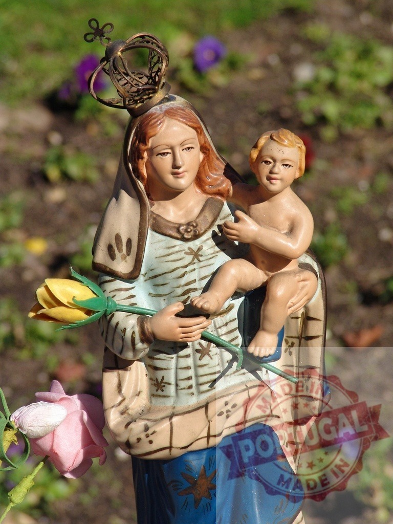Madonna and child statue representing religion and motherhood | Madonna and child sculpture with yellow rose standing in a garden - Realisiert mit Pictrs.com