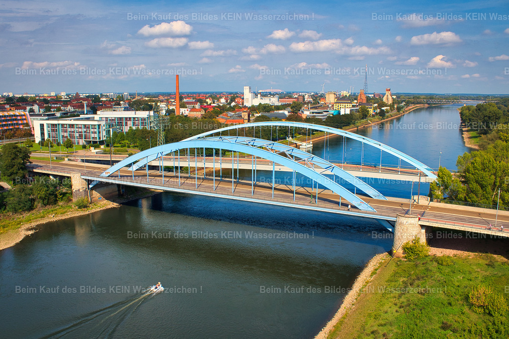 Magdeburg-Jerusalembrücke-Elbe-9798 | Die beiden markanten blauen Jerusalembrücken überspannen die Elbe im Norden der Magdeburger Innenstadt und verbinden die westlich und östlich der Elbe gelegenen Stadtbereiche. Die beiden Brücken sind heute Teil des Nordbrückenzugs und führen die Bundesstraße 1 über den Fluss.Interessant ist auch ihre Geschichte: Die beiden nebeneinanderliegenden Bauwerke sind nicht gleich alt. Die südliche Jerusalembrücke entstand 1952, die nördliche Brücke wurde 1996 als Neubau ergänzt. Erst seit 1998 tragen beide gemeinsam den Namen Jerusalembrücken.Aus der Vogelperspektive wird besonders deutlich, warum hier von „den Jerusalembrücken“ die Rede ist: Zwei eigenständige Brücken liegen unmittelbar nebeneinander und bilden gemeinsam einen wichtigen Elbübergang Magdeburgs. - Realisiert mit Pictrs.com