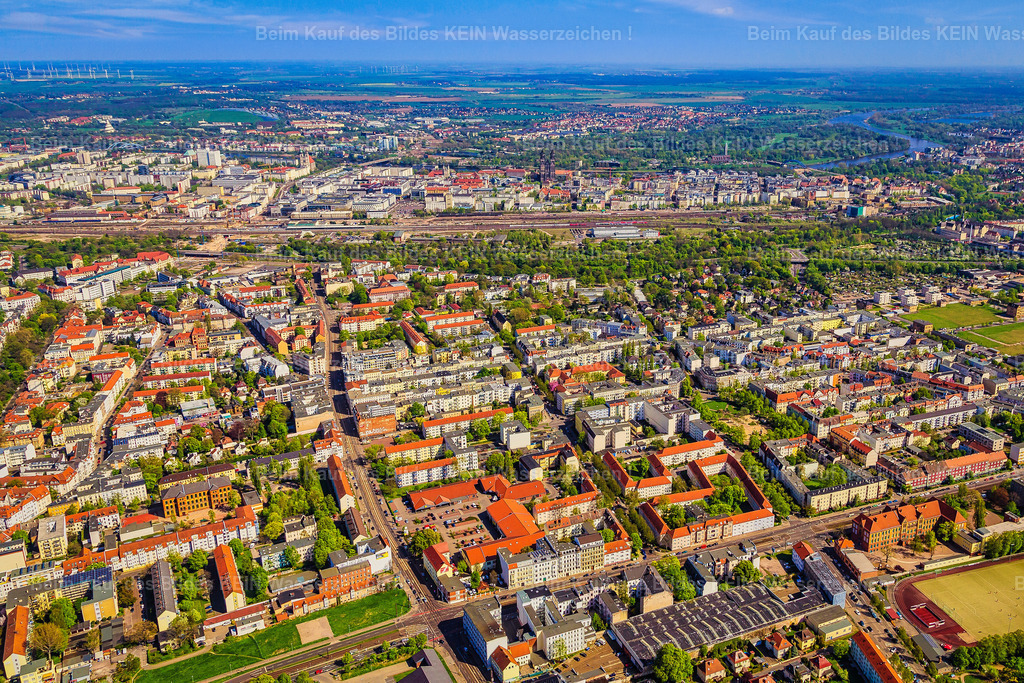 Magdeburg Diesdorfer Kreuzung Westring und Dom-8983 | Blick aus dem Tragschrauber über das dicht bebaute Stadtfeld Ost in Richtung Osten zur Magdeburger Innenstadt.  –  –  Im Vordergrund reicht die Aufnahme vom Bereich der Kreuzung am Westring bis zur Glacis-Anlage und den dahinterliegenden Bahnanlagen. Der Schellheimer Platz liegt im weiteren Verlauf des Stadtteils. Dahinter öffnet sich der Blick auf die Innenstadt mit dem markanten Magdeburger Dom. Bis zum Horizont erstreckt sich die dicht bebaute Stadtsilhouette.  –  –  Das Luftbild zeigt eindrucksvoll die geschlossene Gründerzeit- und Wohnbebauung von Stadtfeld Ost und seine unmittelbare Verbindung zur Innenstadt.  –  – Dieses Luftbild zeigt Magdeburg-Stadtfeld Ost aus dem Tragschrauber in Richtung Osten. Im Vordergrund reicht der Blick vom Bereich der Kreuzung am Westring über die grüne Glacis-Anlage bis zu den dahinterliegenden Bahnanlagen. Im weiteren Verlauf des Stadtteils liegt der Schellheimer Platz, eingebettet in die dicht bebaute Wohnlandschaft. Dahinter erhebt sich der Magdeburger Dom als markanter Orientierungspunkt der Innenstadt. Bis zum Horizont erstreckt sich die geschlossene Stadtsilhouette mit ihren zahlreichen Wohnhäusern und Straßenzügen. –  – Die Aufnahme verdeutlicht, wie eng Stadtfeld Ost mit der Magdeburger Innenstadt verbunden ist. Die gewachsene Gründerzeitbebauung, vertraute Plätze und grüne Bereiche prägen den Charakter des Viertels. Für viele Magdeburger ist dieser Anblick ein Stück Heimat – voller Erinnerungen an Straßen, Wohnhäuser und Orte, die zum eigenen Leben gehören. –  – Sie wohnen in Stadtfeld Ost, sind hier aufgewachsen oder verbinden persönliche Erinnerungen mit diesem Teil Magdeburgs? Dann holen Sie sich ein Stück Heimat nach Hause. Dieses Luftbild können Sie als hochwertige Leinwand oder als Wandbild bestellen – für das Wohnzimmer, das Büro oder als persönliches Geschenk für Menschen, die Magdeburg im Herzen tragen. - Realisiert mit Pictrs.com