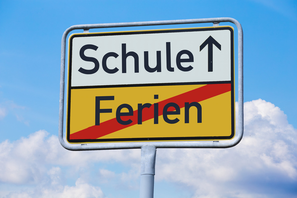 FERIEN und SCHULE auf einem Ortsausgangsschild | Symbolbild Schulstart: Ortsausgangsschild mit den Begriffen FERIEN und SCHULE (Composing) - Realisiert mit Pictrs.com
