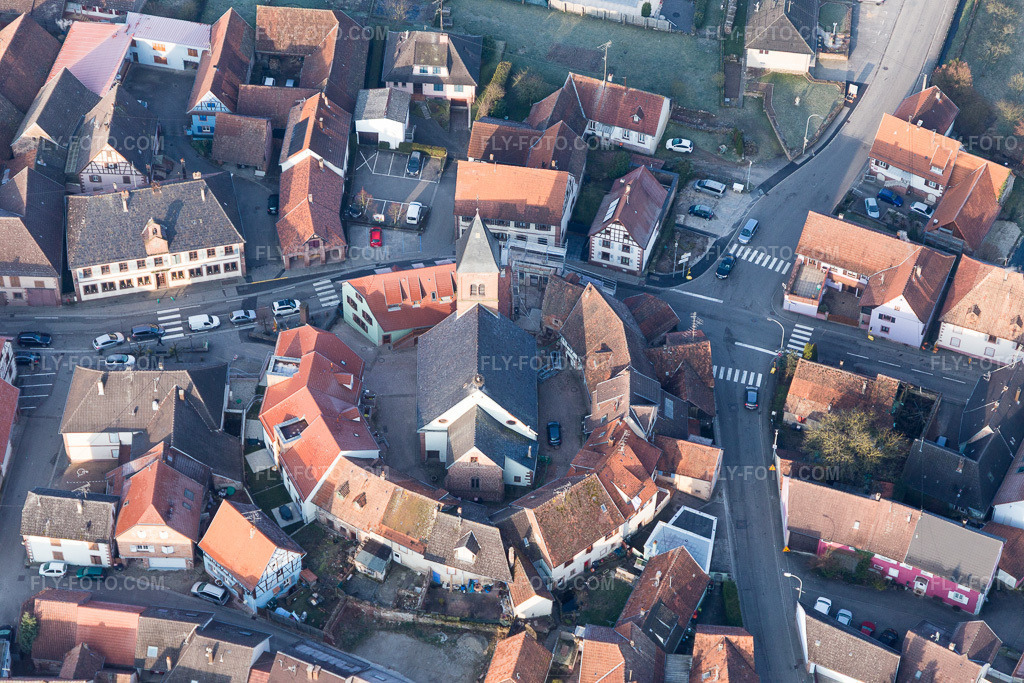 Aerial view: Lutheran-Protestant fortified church in the village center, surrounded by a ring of houses in Dossenheim-sur-Zinsel in the state Bas-Rhin, France.Photo: IMG_105327.jpg taken on 03/25/2018 by Werner Riehm/FLY-FOTO.comResolution of the original: 5472 x 3648 px