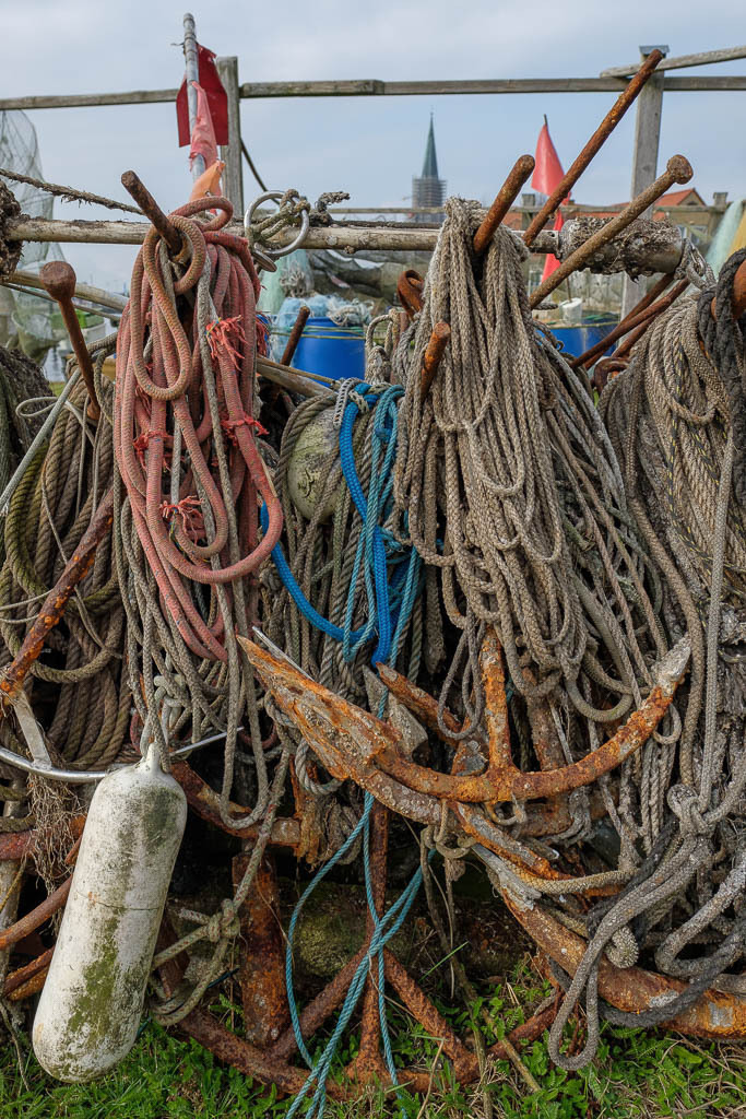 zeitenwende-farbe-01-09 | Die Landungsbrücken am Holmer Strand sind grasbewachsene Anleger der Schleswiger Fischer. Hier machen sie seit Jahrhunderten ihre Boote fest und lagern ihr Material wie diese Anker, Taue und Fender. - Realisiert mit Pictrs.com