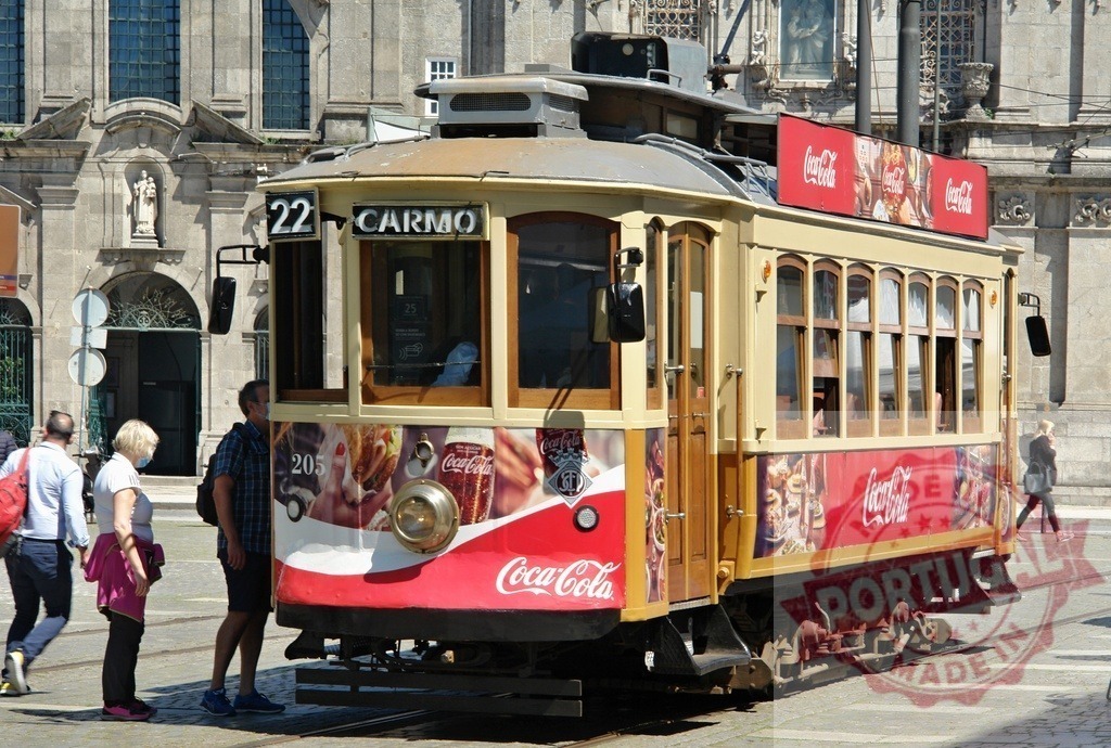 Vintage tram arriving at Carmo stop in Porto Portugal | Historic yellow tram 22 with Coca-Cola advertisements riding on tracks in city street - Realisiert mit Pictrs.com