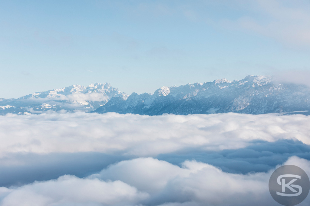 Über den Wolken – Winterliches Bergpanorama in den Alpen | Ein beeindruckendes Alpenpanorama ragt über einem dichten Wolkenmeer empor. Klare Winterluft, sanftes Licht und die majestätische Bergkette schaffen eine ruhige, fast surreale Stimmung. Professionelle Landschaftsfotografie von Stefan Kuhn. - Realisiert mit Pictrs.com