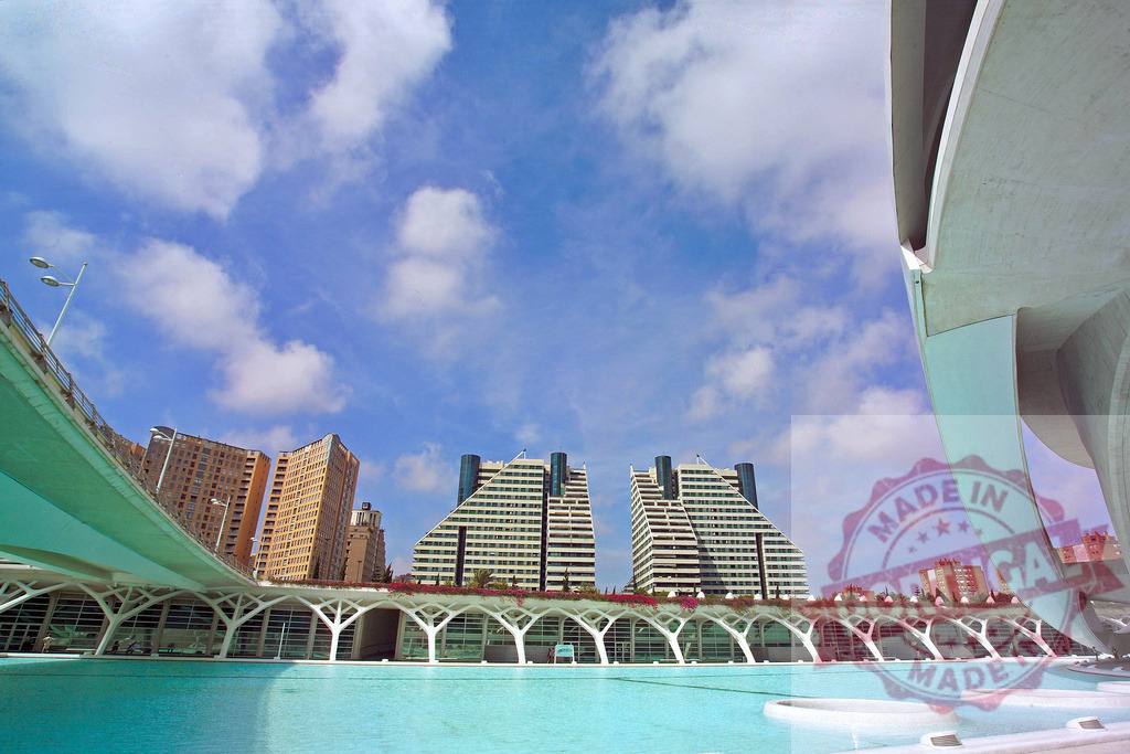 City of Arts and Sciences reflecting in the water on a sunny day | Modern architecture of the City of Arts and Sciences in Valencia, Spain, reflected in a pool of water under a blue sky - Realized with Pictrs.com