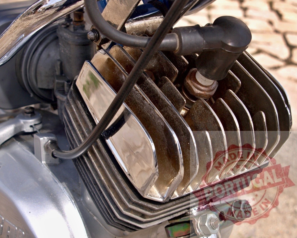 Motorcycle engine details showing cylinder head and spark plug | Air-cooled motorcycle engine with cylinder head fins and spark plug, representing power - Realized with Pictrs.com