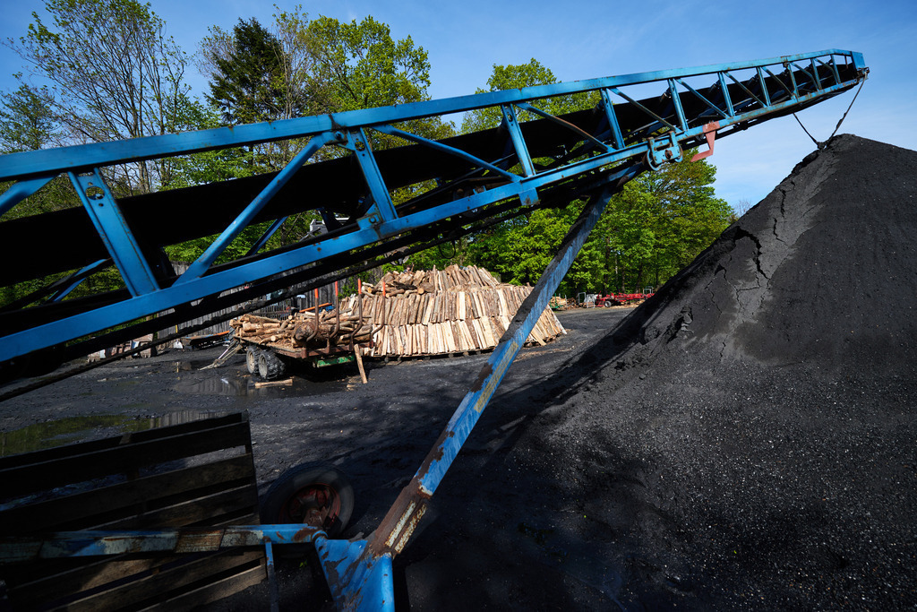 ein Förderband mit Blick auf den Meiler. | Michelbach, Austria - May 08, 2019: Waldköhlerei Hochecker, die 2011 in das Nationale Verzeichnis des immateriellen Kulturerbes der UNESCO aufgenommen wurde, produziert noch echte Holzkohle; ein Förderband mit Blick auf den Meiler. - Realisiert mit Pictrs.com