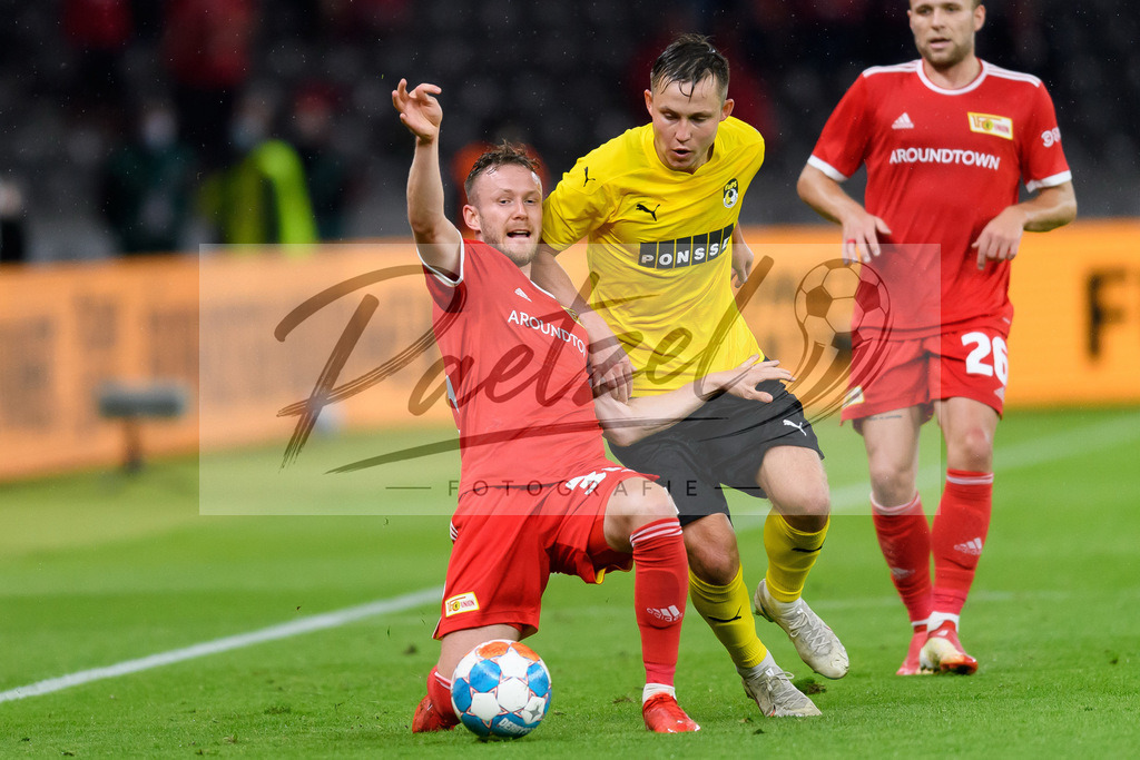 FCUKUO20210826_027 | Fussball, Herren: Janis Ikaunieks (Kuopion PS) und Cedric Teuchert (1.FC Union Berlin) im Zweikampf beim Spiel der UEFA Conference League zwischen 1. FC Union Berlin und Kuopion PS im Olympiastadion am 26.08.2021 in Berlin, Deutschland. - Realisiert mit Pictrs.com