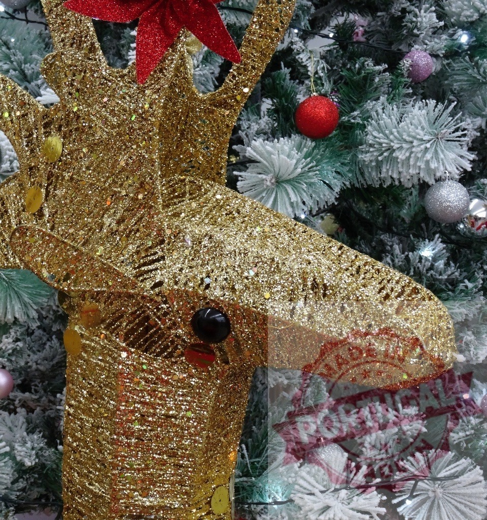 Golden reindeer decoration hanging on a christmas tree | Golden reindeer christmas decoration with red flower hanging on christmas tree - Realisiert mit Pictrs.com