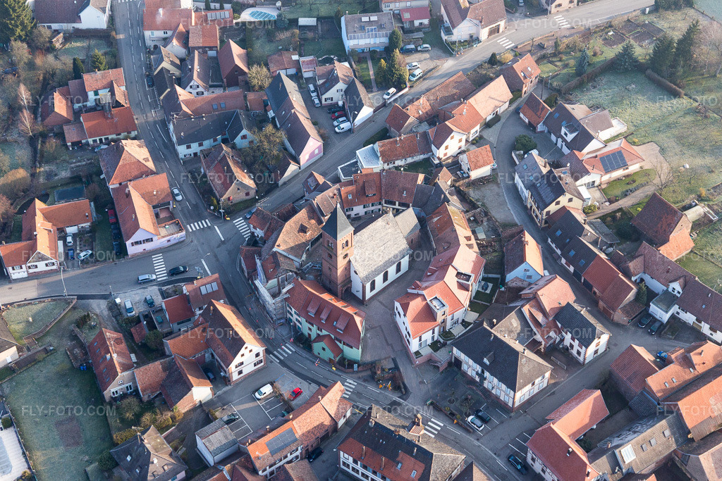 Aerial view: Lutheran-Protestant fortified church in the village center, surrounded by a ring of houses in Dossenheim-sur-Zinsel in the state Bas-Rhin, France.Photo: IMG_105333.jpg taken on 03/25/2018 by Werner Riehm/FLY-FOTO.comResolution of the original: 5472 x 3648 px