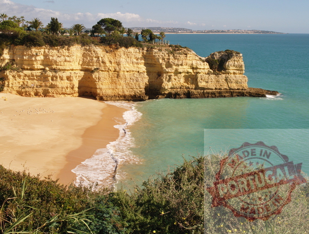 Algarve coastline with sandy beach and turquoise ocean | Golden cliffs frame a secluded beach with clear turquoise ocean water on a sunny day - Realized with Pictrs.com