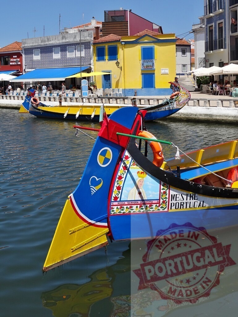 Moliceiro boats cruising Aveiro canal in Portugal. Aveiro - Portugal | Colorful Moliceiro boats navigating a canal in Aveiro, Portugal, with vibrant architecture - Realisiert mit Pictrs.com