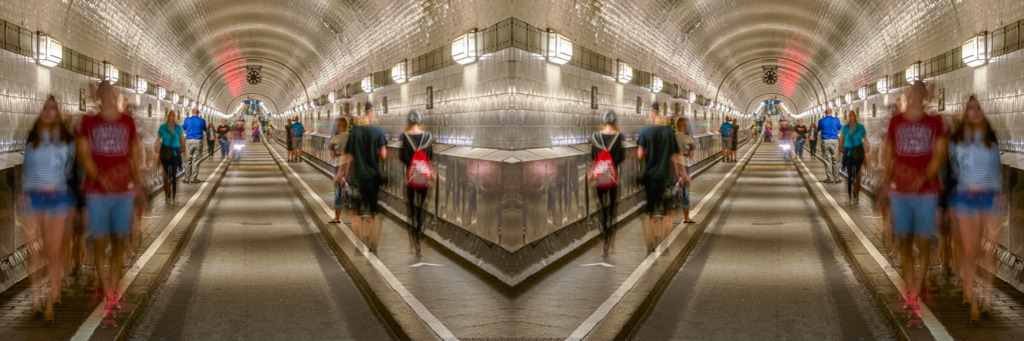 St.-Pauli-Elbtunnel | St.-Pauli-Elbtunnel in Hamburg, auch Alter Elbtunnel genannt. Er wurde 1911 eröffnet und ist rund 426 Meter lang. Durch eine längere Belichtungszeit der Aufnahme erhalten die Passanten eine dynamische Wirkung. — Das Bild wurde horizontal gespiegelt. Auflösung des Originals: 12030 x 4010 px. - Realisiert mit Pictrs.com