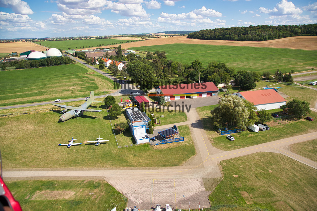 Pilot_4156 | Die Luftaufnahmen zeigen den Flugplatz Ballenstedt mit Start- und Landebahn, Hangars und dem umliegenden Harzvorland. Weitere Bilder entstanden direkt während des Fluges mit dem Tragschrauber. Mit dem Piloten im Vordergrund vermitteln sie einen authentischen Eindruck davon, aus welcher Perspektive meine Luftbilder entstehen und wie unmittelbar das Fotografieren aus dem offenen Tragschrauber ist.
 - Realisiert mit Pictrs.com