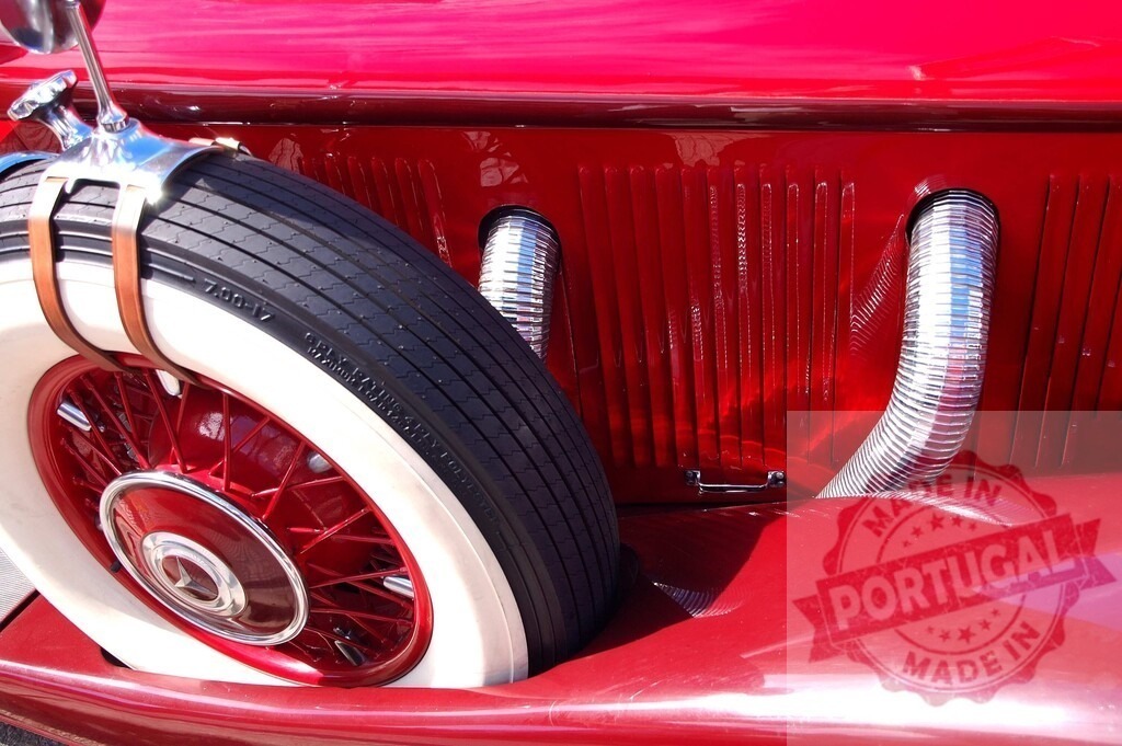 Red vintage car showing spare wheel, exhaust pipe and red hubcap | Close-up of a red vintage car highlighting the spare wheel, exhaust pipe, and red hubcap - Realisiert mit Pictrs.com