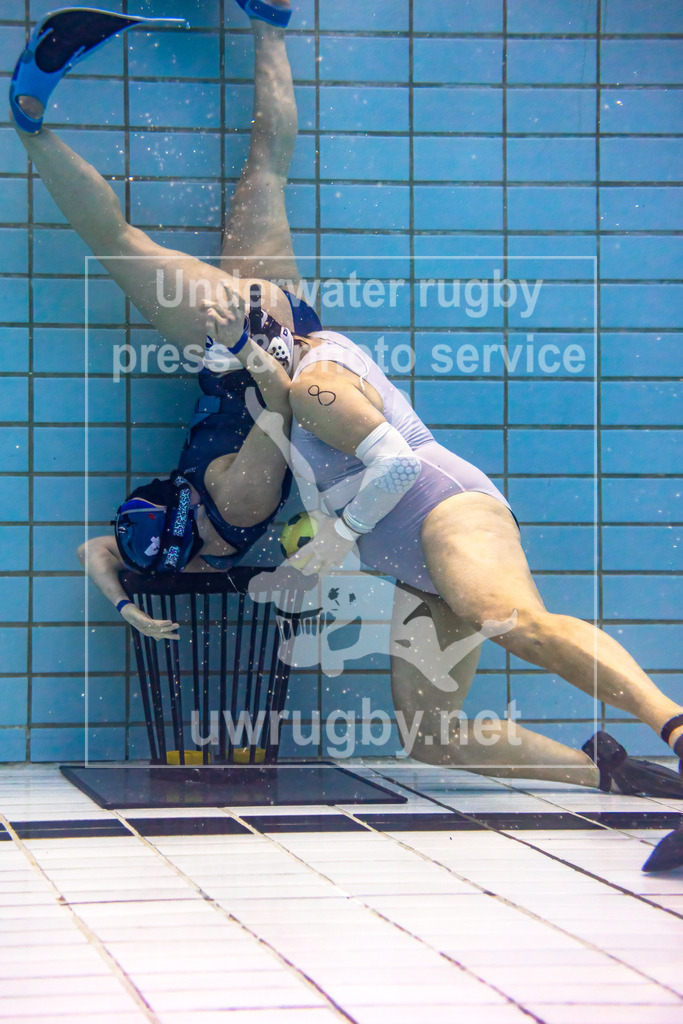 24. - 26.11.2023: Unterwasser-Rugby Champions Cup 2023  | Strafstoß im Damen-Spiel: Amager Uv-Rugby (Dänemark) in blau gegen Black Mermaids (Schweden) in weiß. Die schwedische Angreiferin Monika Grunditz (weiß #8) kurz vor dem verwandeln des Strafstoßen gegen die dänische Torwartin Dina Iversen (blau #4). - Realisiert mit Pictrs.com