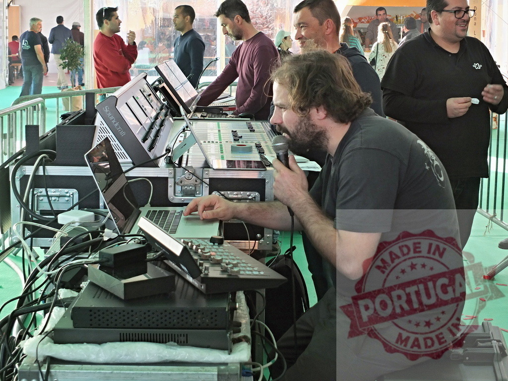 Sound engineer speaking on microphone and working on laptop during live event | Sound engineer speaking on microphone and working on laptop during live event, adjusting sound levels and managing audio equipment - Realisiert mit Pictrs.com
