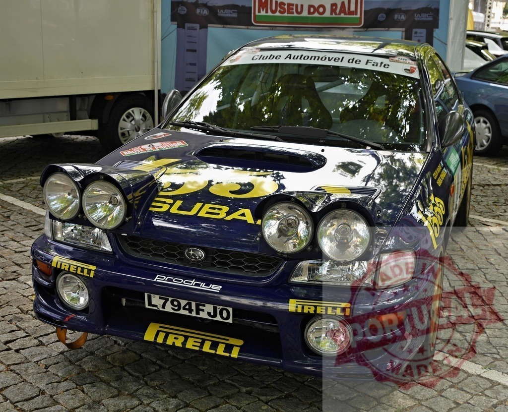 Subaru Impreza WRC rally car on display | Subaru Impreza WRC rally car with sponsor decals parked on cobblestone - Realisiert mit Pictrs.com