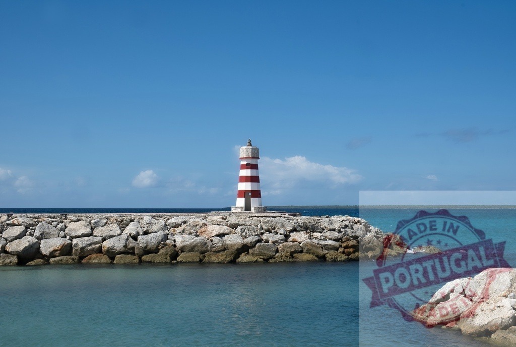 Red and white striped lighthouse standing on a rocky breakwater | Lighthouse standing on a rock breakwater, guiding ships from the calm blue ocean - Realisiert mit Pictrs.com