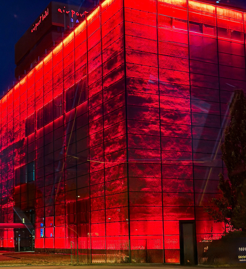 Urban Red Glow – Abstrakt illuminierte moderne Architektur-Fotokunst | Bringen Sie die pulsierende Energie der Nacht und kompromisslose Modernität an Ihre Wände. Diese beeindruckende Architekturfotografie zeigt die intensiv rot leuchtende, strukturierte Fassade des Grand Casino Basel in einer faszinierenden, fast abstrakten Ästhetik. Das kraftvolle Zusammenspiel aus tiefem Nachtblau und dem glühenden, strukturierten Rot erzeugt eine enorme visuelle Dynamik. Ein exklusives Kunstwerk im urbanen Industrial-Stil, das in modern reduzierten Wohnzimmern, stylischen Lofts oder repräsentativen Geschäftsräumen und Bars ein absolutes optisches Highlight setzt.Material-Empfehlung: Um die maximale Leuchtkraft des Rots und die tiefen Schwarztöne perfekt zur Geltung zu bringen, empfehle ich dieses Motiv dringend auf glänzendem Acrylglas oder als Alu-Dibond Fine-Art-Print. Das Material unterstreicht den cleanen, architektonischen Charakter perfekt.Setzen Sie ein mutiges Design-Statement in Ihren Räumen – wählen Sie jetzt Ihre Wunschgröße und bestellen Sie dieses exklusive Wandbild.[Archiv-Nr. #0106] - Realisiert mit Pictrs.com