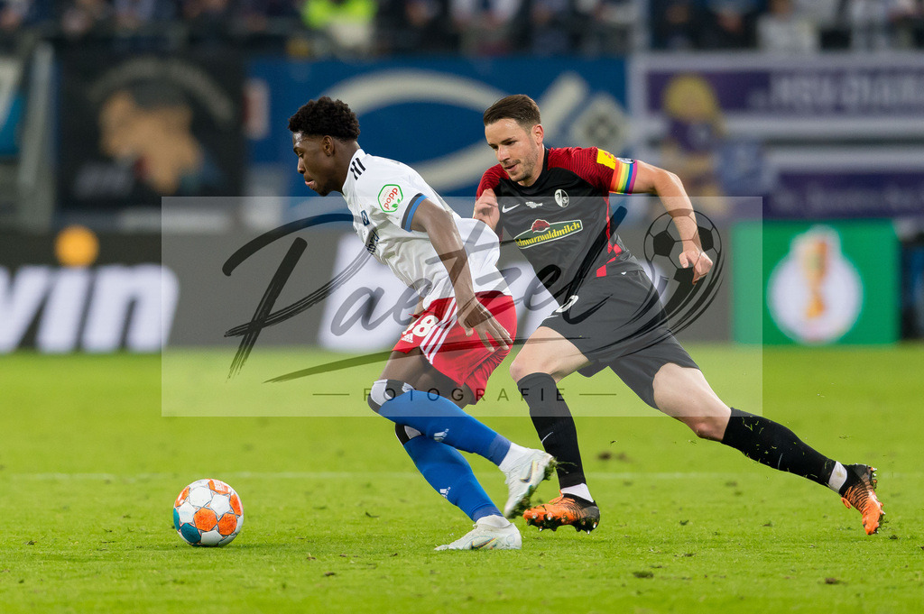 HSVSCF20220419_207 | Fussball, Herren: Faride Alidou (Hamburger SV) und Christian Guenter (SC Freiburg) im Zweikampf beim DFB-Pokal-Halbfinalspiel zwischen Hamburger SV und SC Freiburg im Volksparkstadion am 19.04.2022 in Hamburg, Deutschland.DFB / DFL REGULATIONS PROHIBIT ANY USE OF PHOTOGRAPHS AS IMAGE SEQUENCES AND/OR QUASI-VIDEO. - Realisiert mit Pictrs.com