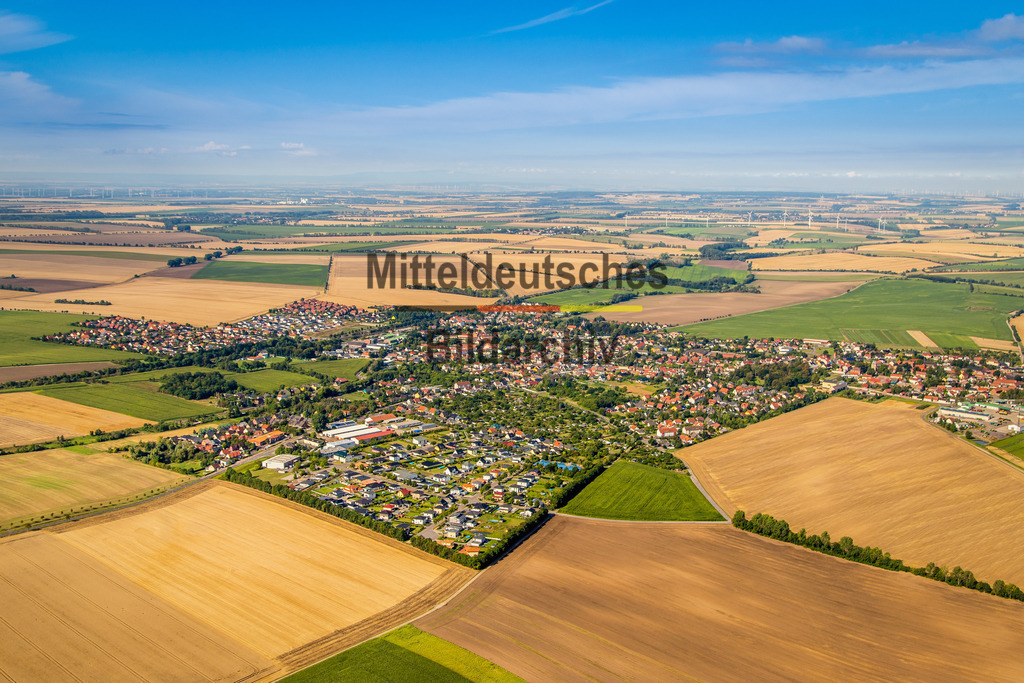 27_Niederndodeleben-6705 | Diese Luftaufnahme zeigt einen Ort im Landkreis Börde aus der Vogelperspektive. Das Bild entstand aus einem Tragschrauber und vermittelt einen eindrucksvollen Überblick über die Siedlungsstruktur, die umgebende Landschaft und die charakteristischen Merkmale des Ortes. Die Aufnahme dokumentiert Architektur, Straßenverläufe und Grünflächen aus einer außergewöhnlichen Perspektive und ist Teil des Mitteldeutschen Bildarchivs von Luftbildfotograf Steffen Lehmann. - Realisiert mit Pictrs.com