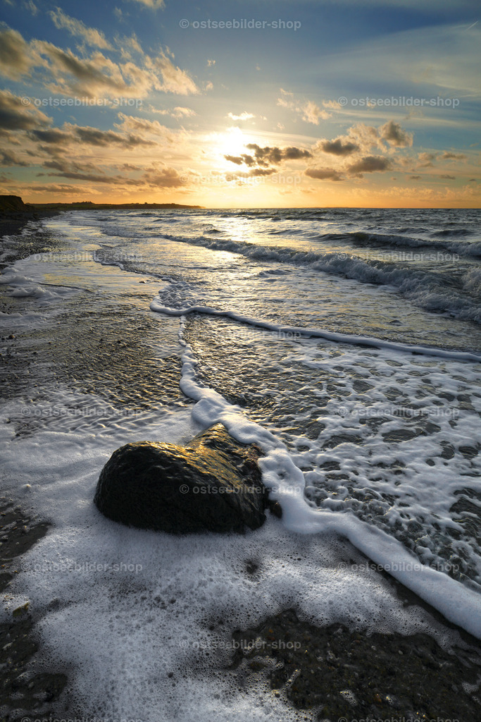 Auslaufen der Wellen im Abendlicht | Ostseewellen schieben Schaumkränze über den nassen Sand vor der Steilküste.