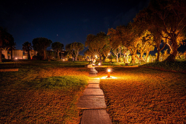 Weg in der Nacht durch einen Park | Der Weg schlängelt sich durch einen Park und wird mit Laternen beleuchtet - Realisiert mit Pictrs.com