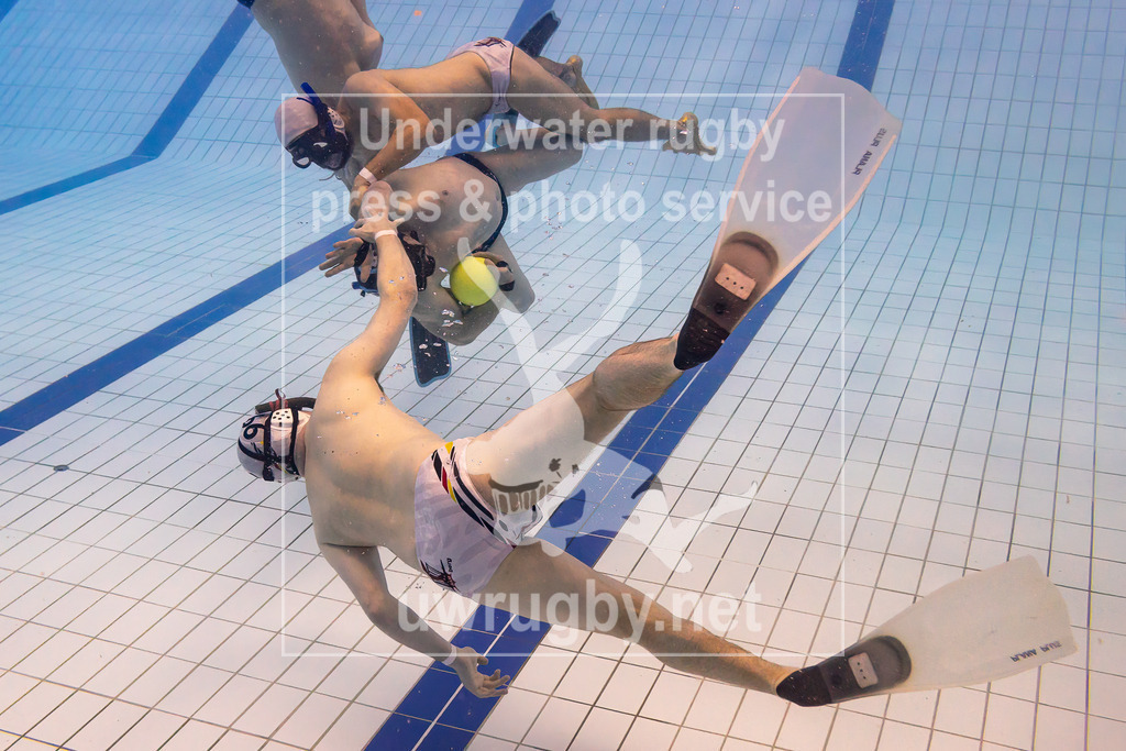 TC Bamberg vs. TSV Malsch, Unterwasser-Rugby, 1. Bundesliga Süd, 5. Spieltag, 2024/2025, 23.03.2025 | TC Bamberg (weiß) vs. TSV Malsch, (blau). EIn Malscher Spieler im Ballbesitz während er von Veit Hofmann (TC Bamberg, #01) und David Scheffczyk (TC Bamberg, #99) angegriffen wird. - Realisiert mit Pictrs.com