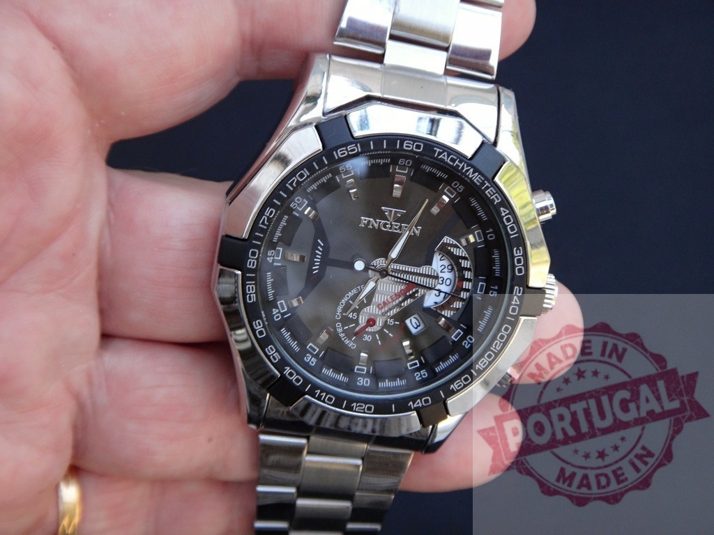 Hand holding luxury FNGERN chronograph wristwatch | Hand holding a modern chronograph wristwatch with a black dial and stainless steel band - Realisiert mit Pictrs.com