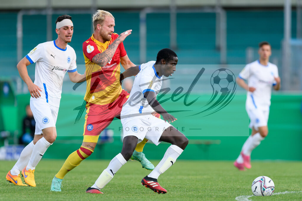 LOTKSC20210809_186 | Fussball, Herren: Philipp Hofmann (Karlsruher SC) und Komlan Fionouke (Sportfreunde Lotte) im Zweikampf beim Spiel der 1. Runde im DFB-Pokal zwischen SF Lotte und Karlsruher SC im Stadion am Lotter Kreuz am 09.08.2021 in Lotte, Deutschland.DFB / DFL REGULATIONS PROHIBIT ANY USE OF PHOTOGRAPHS AS IMAGE SEQUENCES AND/OR QUASI-VIDEO. - Realisiert mit Pictrs.com