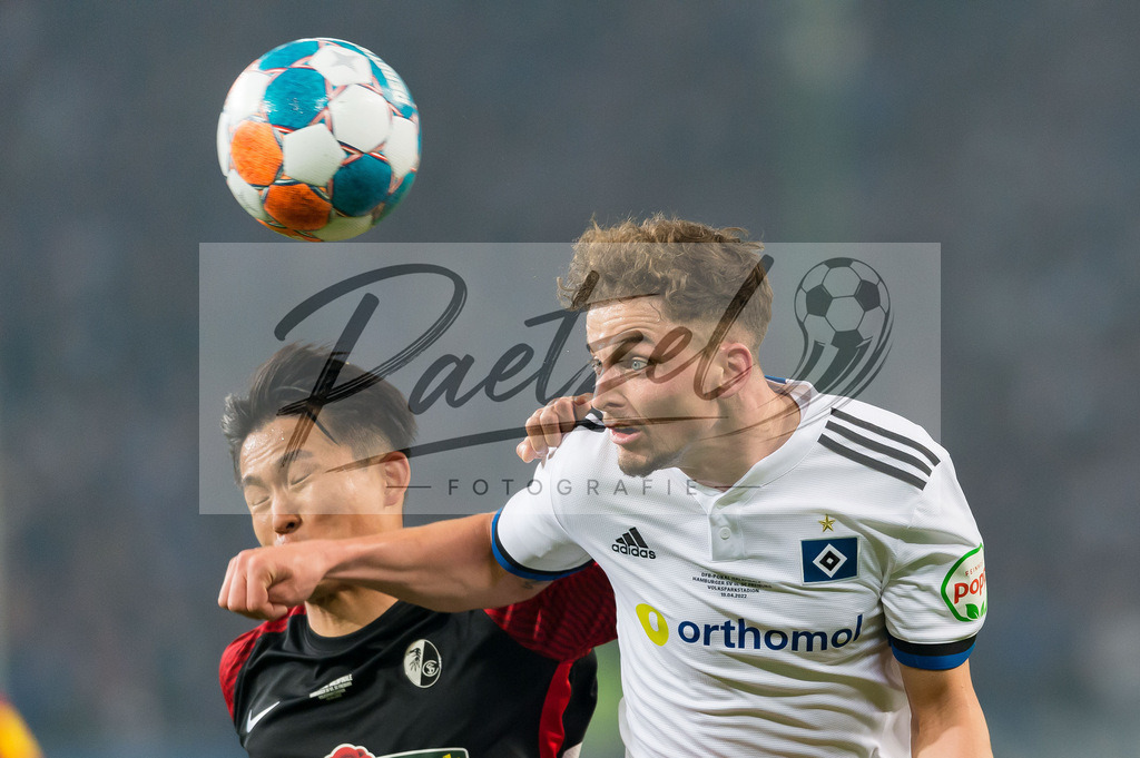 HSVSCF20220419_123 | Fussball, Herren: Woo-yeong Jeong (SC Freiburg) und Moritz Heyer (Hamburger SV) im Zweikampf beim DFB-Pokal-Halbfinalspiel zwischen Hamburger SV und SC Freiburg im Volksparkstadion am 19.04.2022 in Hamburg, Deutschland.DFB / DFL REGULATIONS PROHIBIT ANY USE OF PHOTOGRAPHS AS IMAGE SEQUENCES AND/OR QUASI-VIDEO. - Realisiert mit Pictrs.com