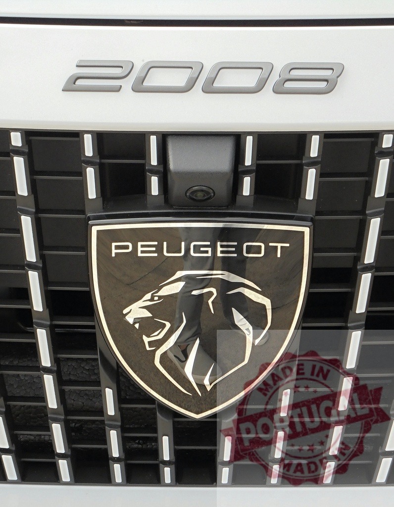Peugeot 2008 car grille with lion emblem | Peugeot 2008 automobile front grille displaying the brand's lion logo - Realized with Pictrs.com