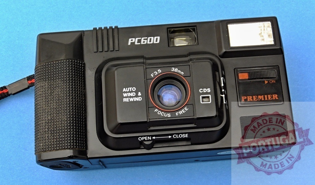 Premier PC600 vintage 35mm film camera on blue background | Premier PC600, a classic 35mm point and shoot film camera, representing photography history - Realized with Pictrs.com