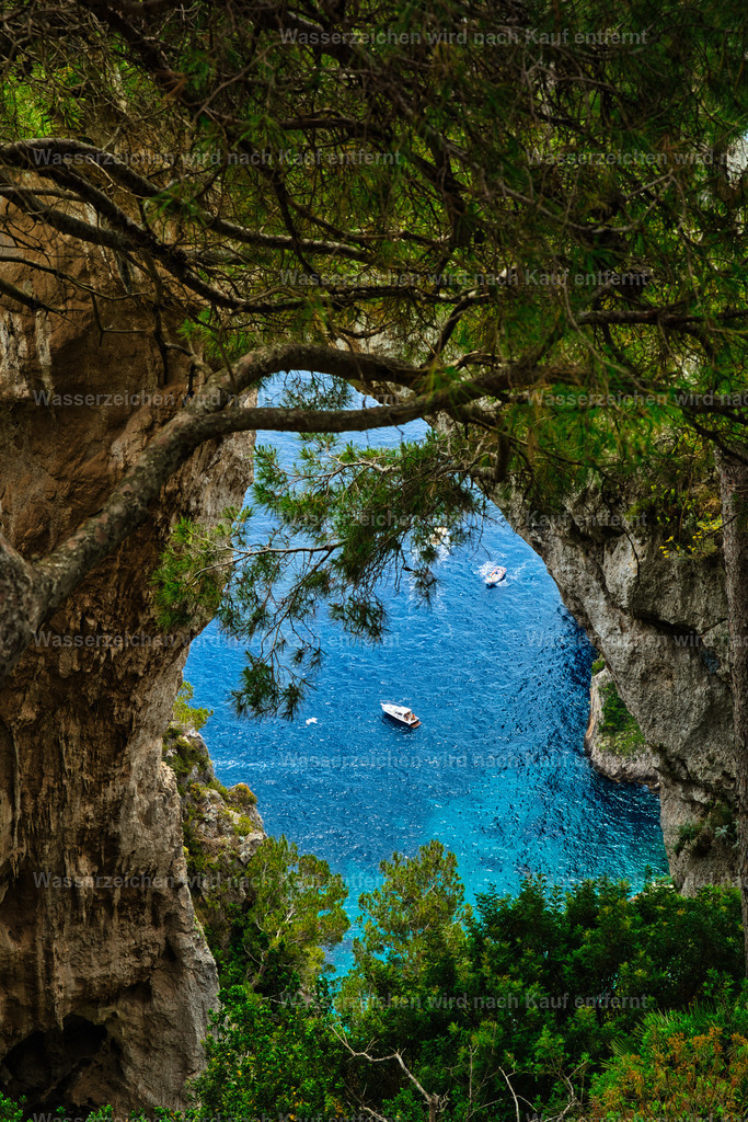 Capri - Blick durch den Arco Naturale | Capri ist eine traumhafte Insel im Golf von Neapel, bekannt für türkisblaues Meer, beeindruckende Felsklippen, mediterrane Landschaften und die berühmten Faraglioni. - Realisiert mit Pictrs.com