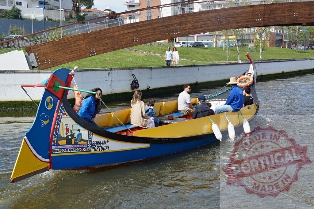 Aveiro moliceiro boat tour in Portugal canal. Aveiro - Portugal | Tourists enjoying a traditional moliceiro boat navigating the canals of Aveiro, Portugal - Realisiert mit Pictrs.com