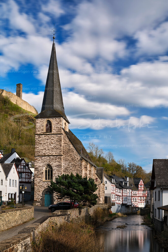 Das noch verschlafene Monreal erwacht im Licht des Frühlings | Die Dreifaltigkeitskirche in Monreal mit Blick auf die Fachwerkhäuser am Elzbach - Realisiert mit Pictrs.com