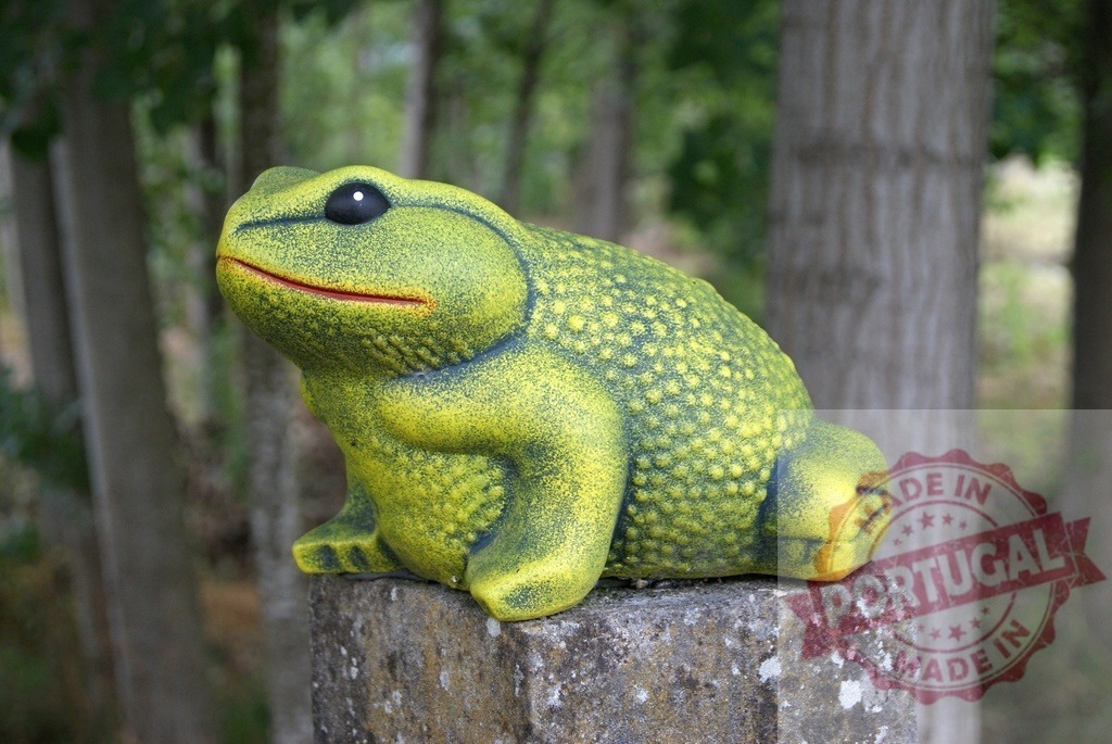 Green frog figurine sitting on stone pillar | Green frog figurine decorates an outdoor garden setting - Realized with Pictrs.com