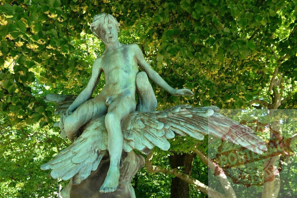 Bronze statue of a boy riding a swan in a park | Weathered bronze sculpture depicting a boy with wings in a natural green environment - Realisiert mit Pictrs.com