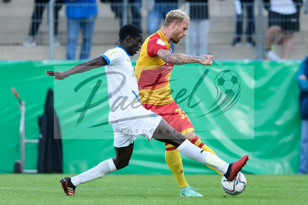 LOTKSC20210809_207 | Fussball, Herren: Philipp Hofmann (Karlsruher SC) und Komlan Fionouke (Sportfreunde Lotte) im Zweikampf beim Spiel der 1. Runde im DFB-Pokal zwischen SF Lotte und Karlsruher SC im Stadion am Lotter Kreuz am 09.08.2021 in Lotte, Deutschland.DFB / DFL REGULATIONS PROHIBIT ANY USE OF PHOTOGRAPHS AS IMAGE SEQUENCES AND/OR QUASI-VIDEO. - Realisiert mit Pictrs.com