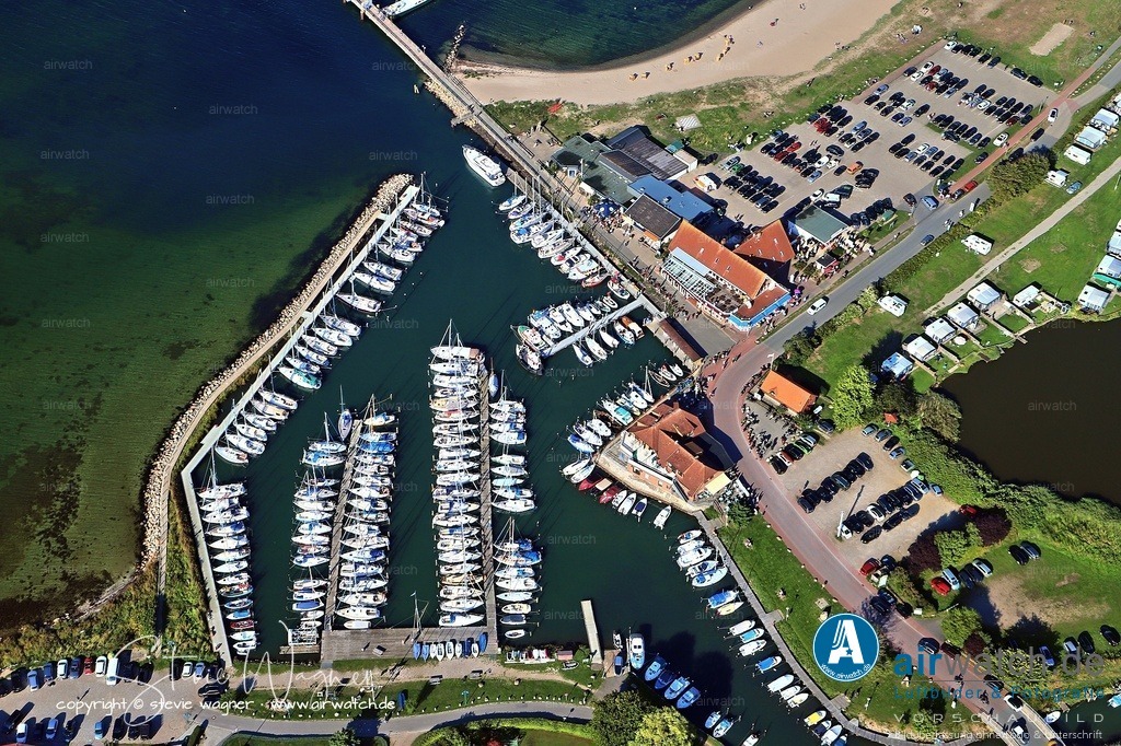 Luftbild Langballigau - Der Hafen ist nicht nur ein beliebter Ankerplatz | Der Hafen ist nicht nur ein beliebter Ankerplatz, sondern auch ein Nothafen, da die geschützte Lage des Hafens dazu beiträgt. Die Deutsche Gesellschaft zur Rettung Schiffbrüchiger (DgzRS) hat hier ihren Rettungskreuzer Werner Kuntze stationiert. Direkt am Hafen befinden sich mehrere Gaststätten, ein Supermarkt, ein Segelmacher, ein Bootszubehör-Shop und eine Poststelle. Zudem gibt es zwei Sanitäranlagen mit Waschgelegenheiten, Duschen und WC.
